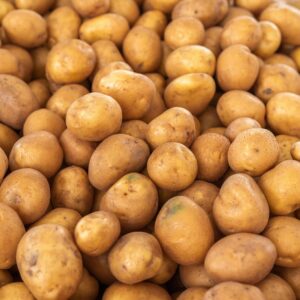 Pile of freshly harvested brown potatoes ready for market sale.
