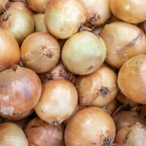 A close-up of fresh organic onions displayed at a market in Bornova, İzmir, Türkiye.
