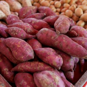 A vibrant selection of fresh sweet potatoes at a local market display highlighting their rich colors and textures.
