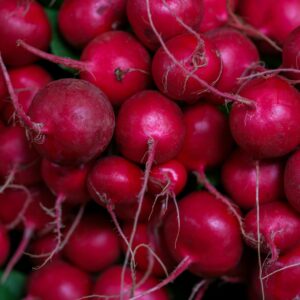 Bright red radishes in market, showcasing fresh organic produce. Ideal for health and nutrition themes.