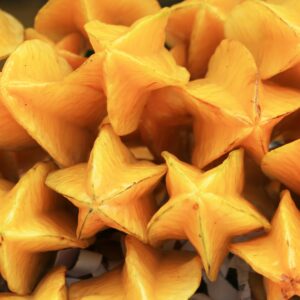 Bright and colorful starfruit (Averrhoa carambola) piled together, showcasing vibrant tropical fruits.