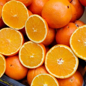 Bright, juicy oranges on display at a market stall, showcasing freshness and vibrant color.