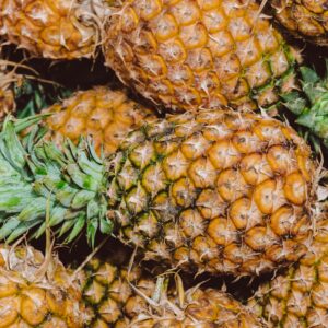Close-up of several ripe pineapples in a vibrant and colorful arrangement.