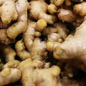 A detailed close-up view of fresh ginger roots in a pile, showcasing their texture and color.