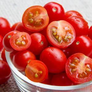 Vibrant cherry tomatoes in a glass bowl, showcasing freshness and vibrant red color.