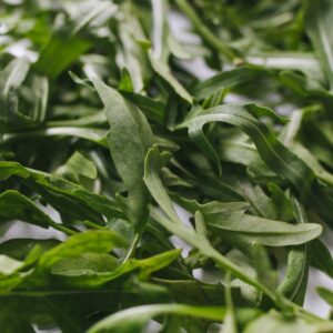 A detailed view of fresh arugula leaves, showcasing their green color and natural texture.